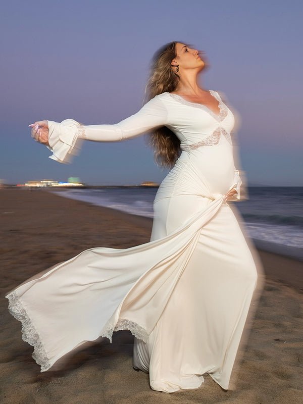 White lace maternity maxi dress with ruffle draped design and elegant silhouette.