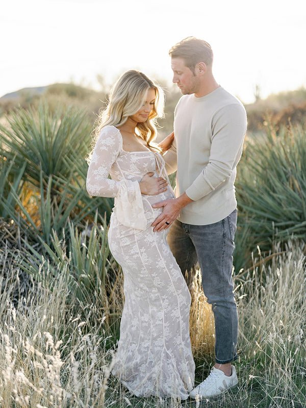 White lace maternity maxi dress with corset square neckline, off-shoulder flare sleeves, and bodycon silhouette, designed for photoshoot.